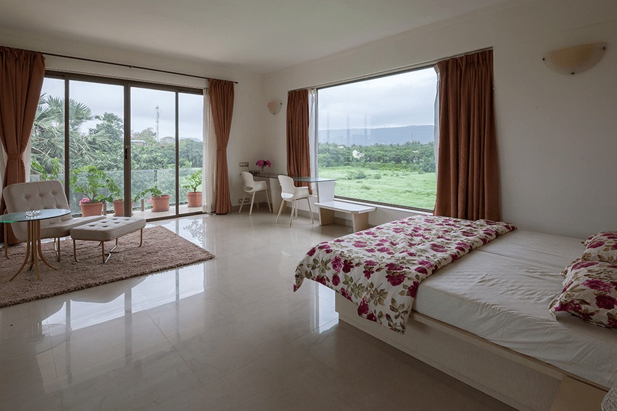 Spacious bedroom with double bed, sitting area, side table and lawn-facing, pet friendly space