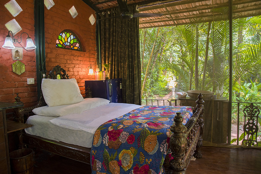 Bedroom with double bed, quirky decor, brick walls and garden-facing