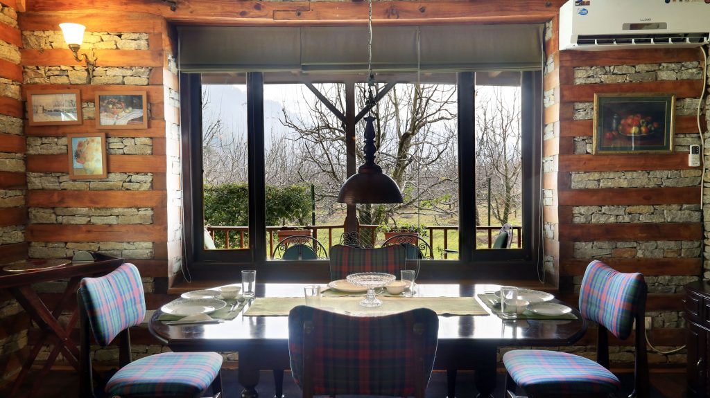 Cozy dining area, wooden and stone interiors, lawn facing