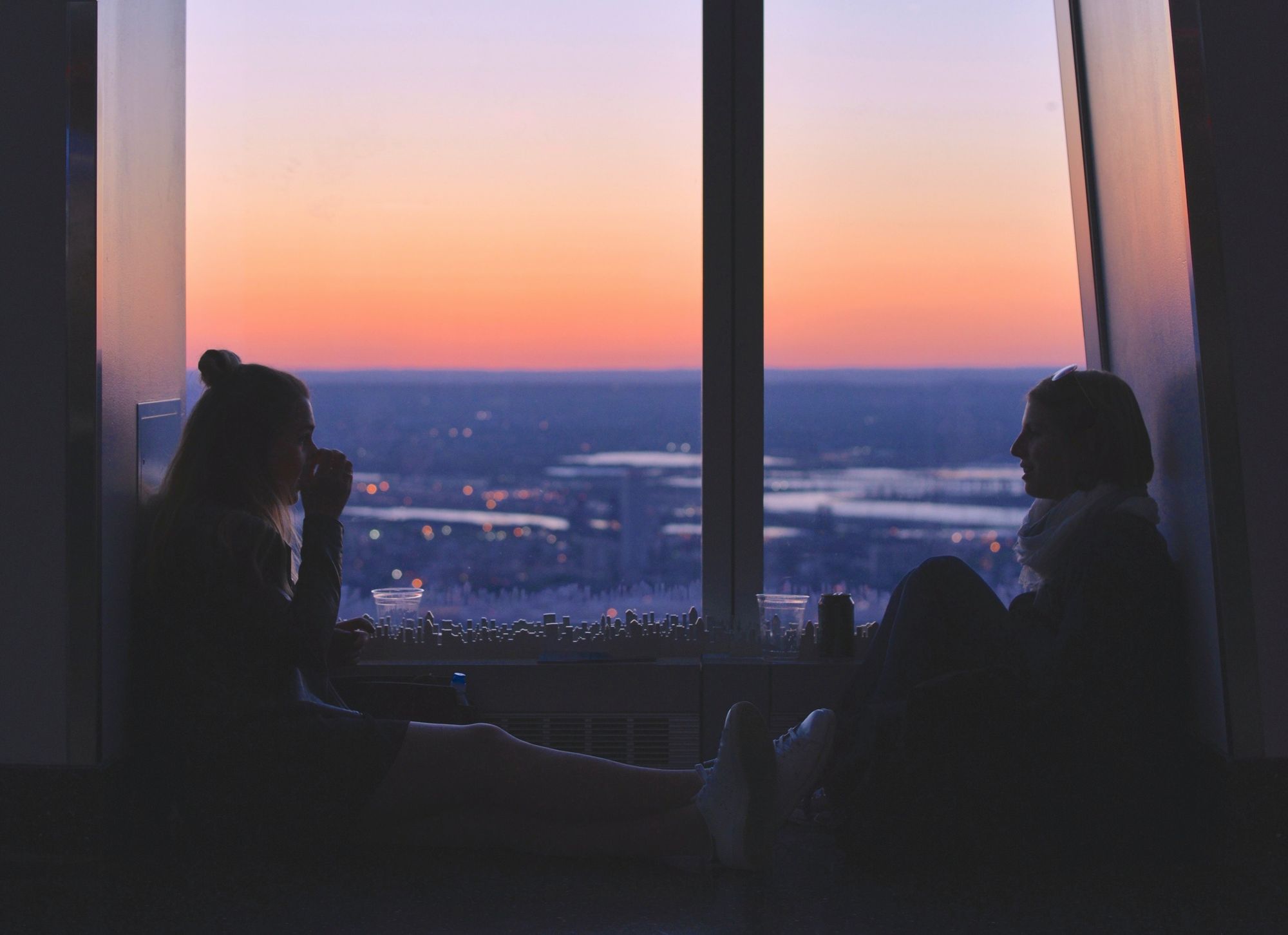 two women sitting near window