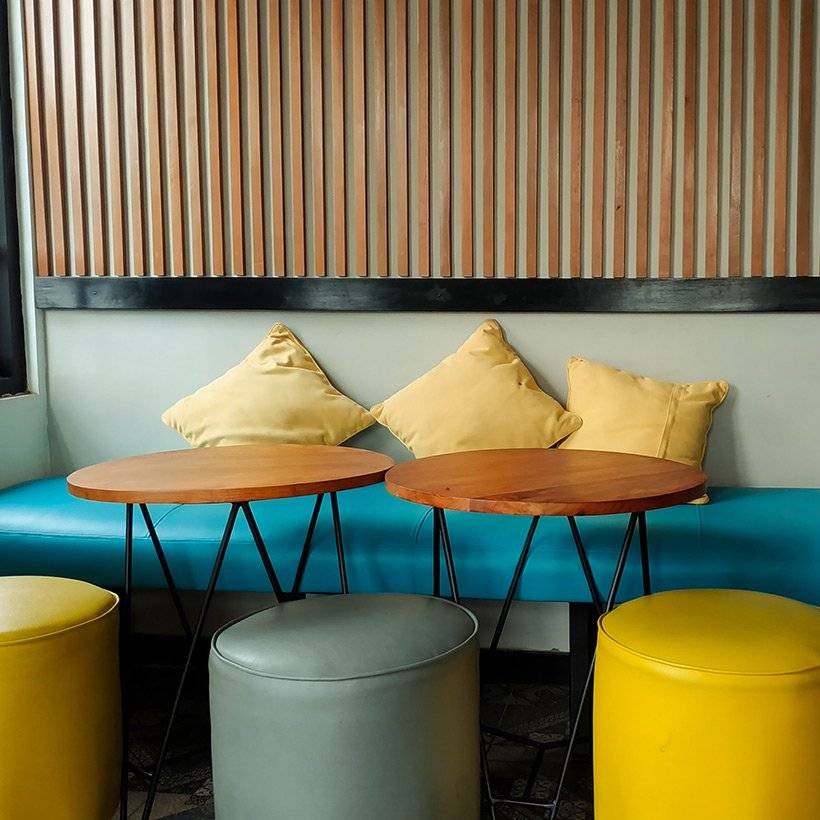 A playful modern dining room design with a big mattress sofa on one side and individual seats on the other side in a casual dining room ideas