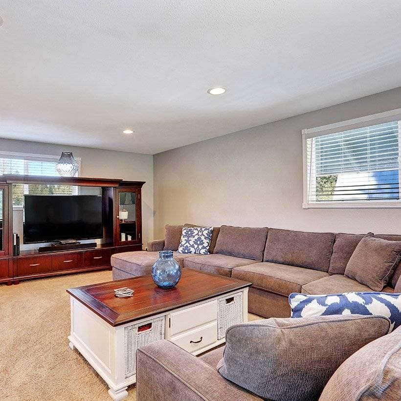Small living room furniture arrangement with sofas on the sides and a big wooden table with a lot of storage inside it in living room center table decor