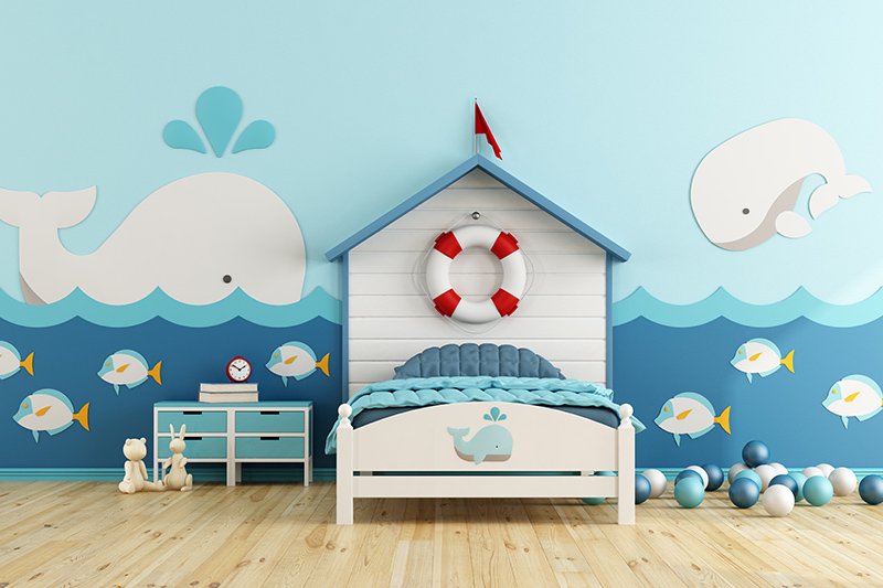 Kids wall decor with aa boat-shaped bed and stickers of whales and bubbly fish for kids room decor