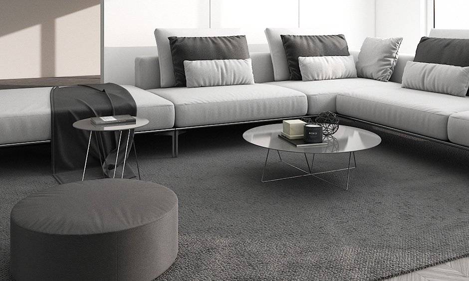 minimalist living room india with sofa set, monochrome pillows and a glass coffee table