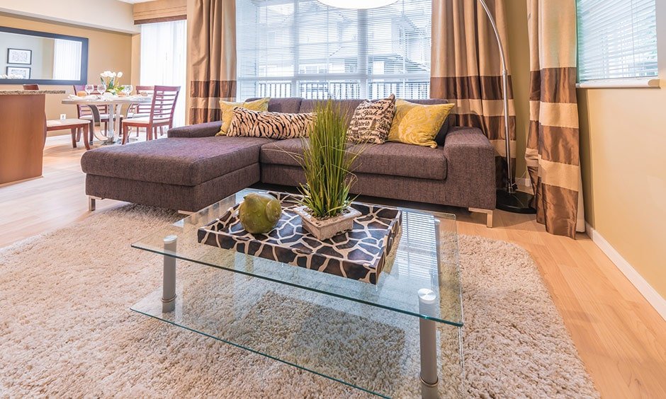 A glass finish coffee table for your living room with a lovely display of decor on it