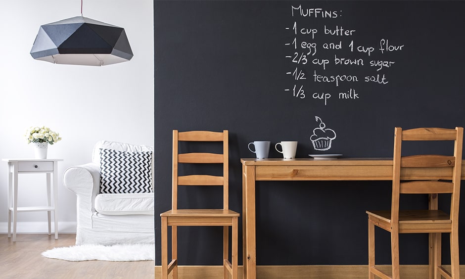 Minimal dining room decor with chalkboard paint on the wall gives dining room