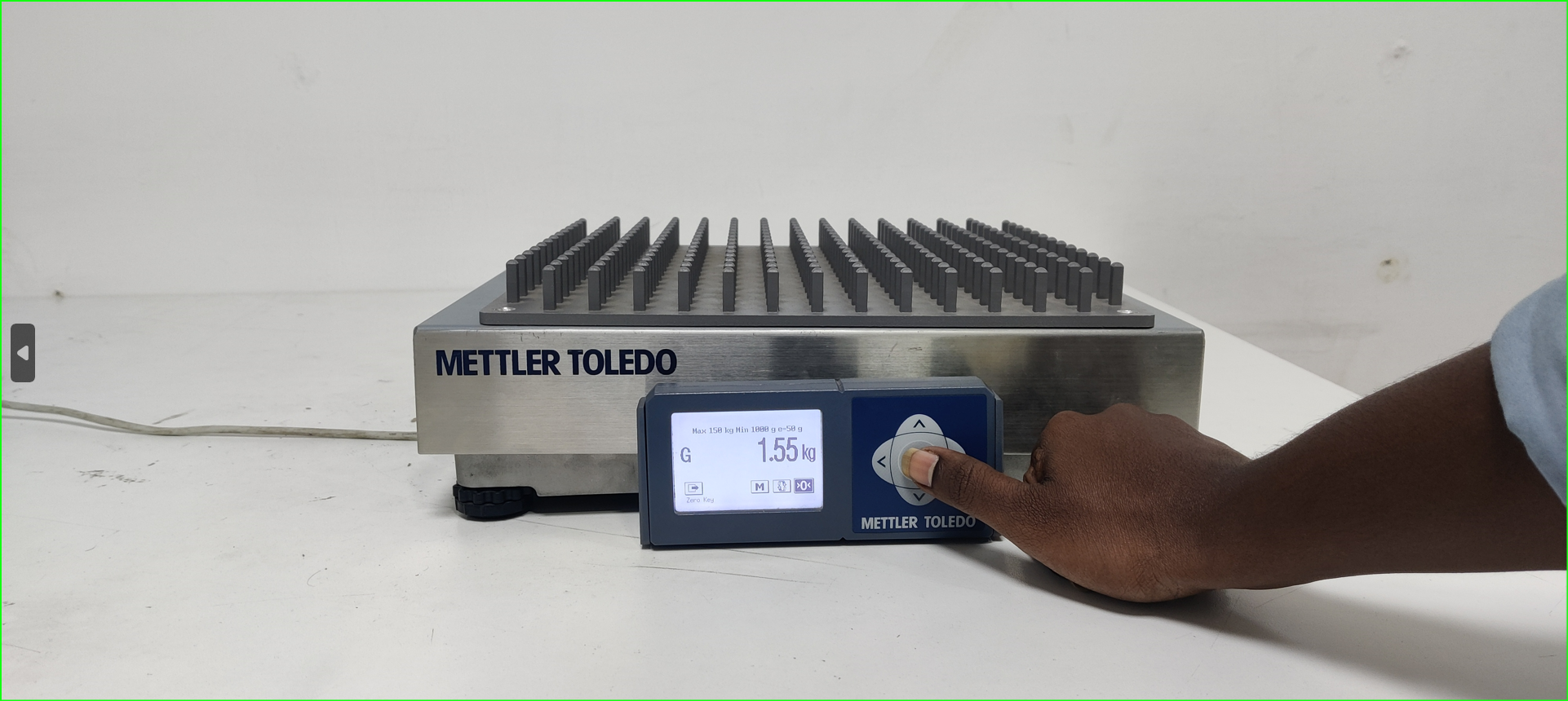 A hand pressing a button on a machine

Description automatically generated