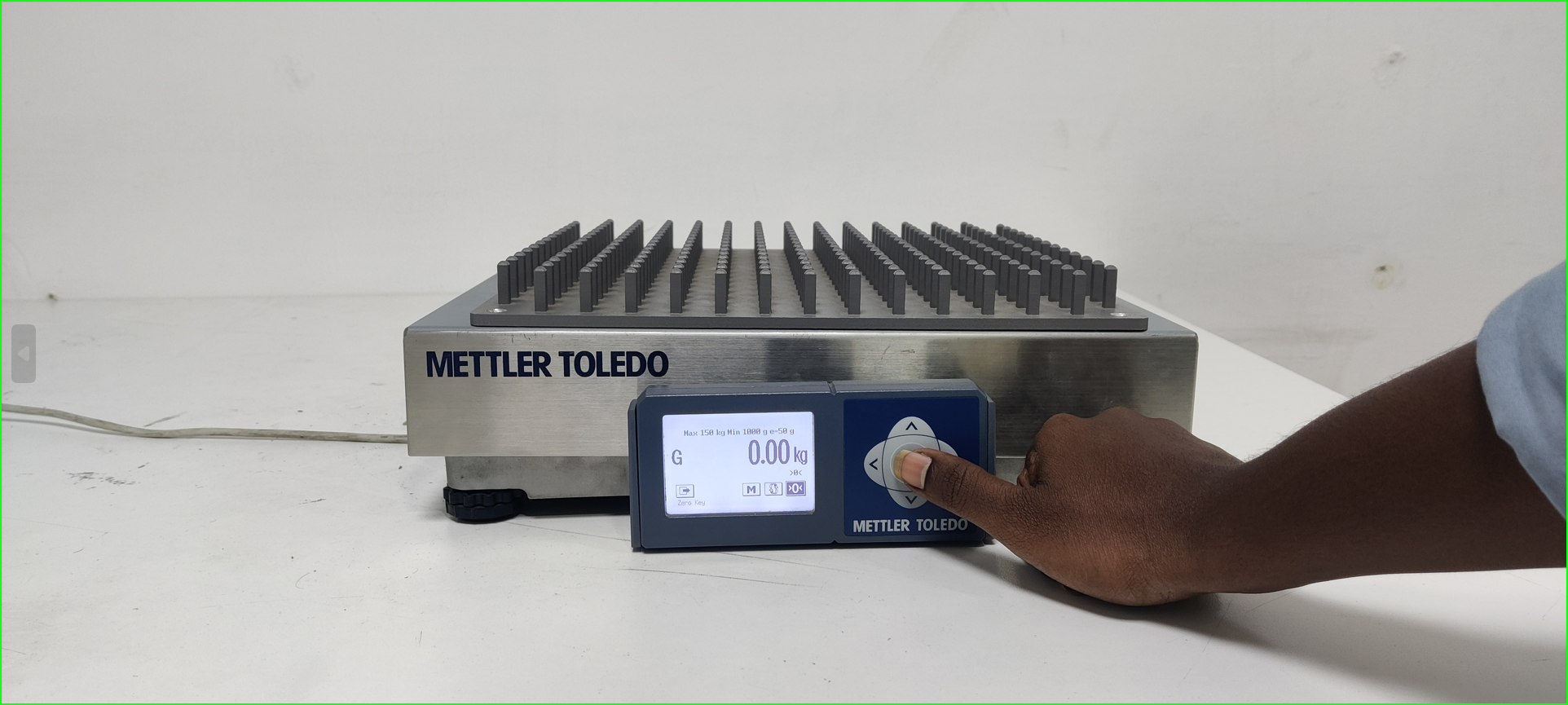 A hand pressing a button on a machine

Description automatically generated