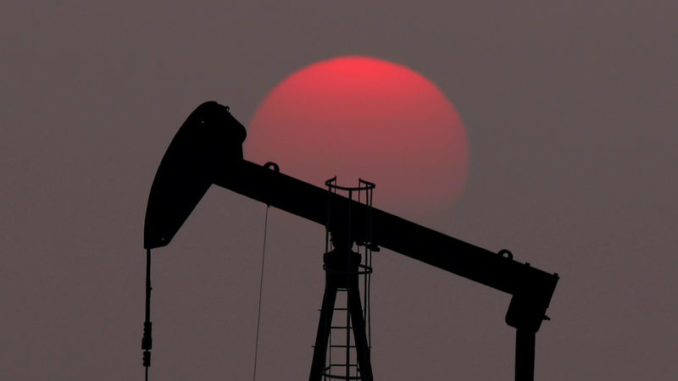 FILE PHOTO: The sun sets behind a pump-jack outside Saint-Fiacre
